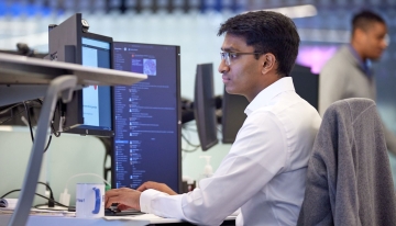 Man sitting at desk working on computer.